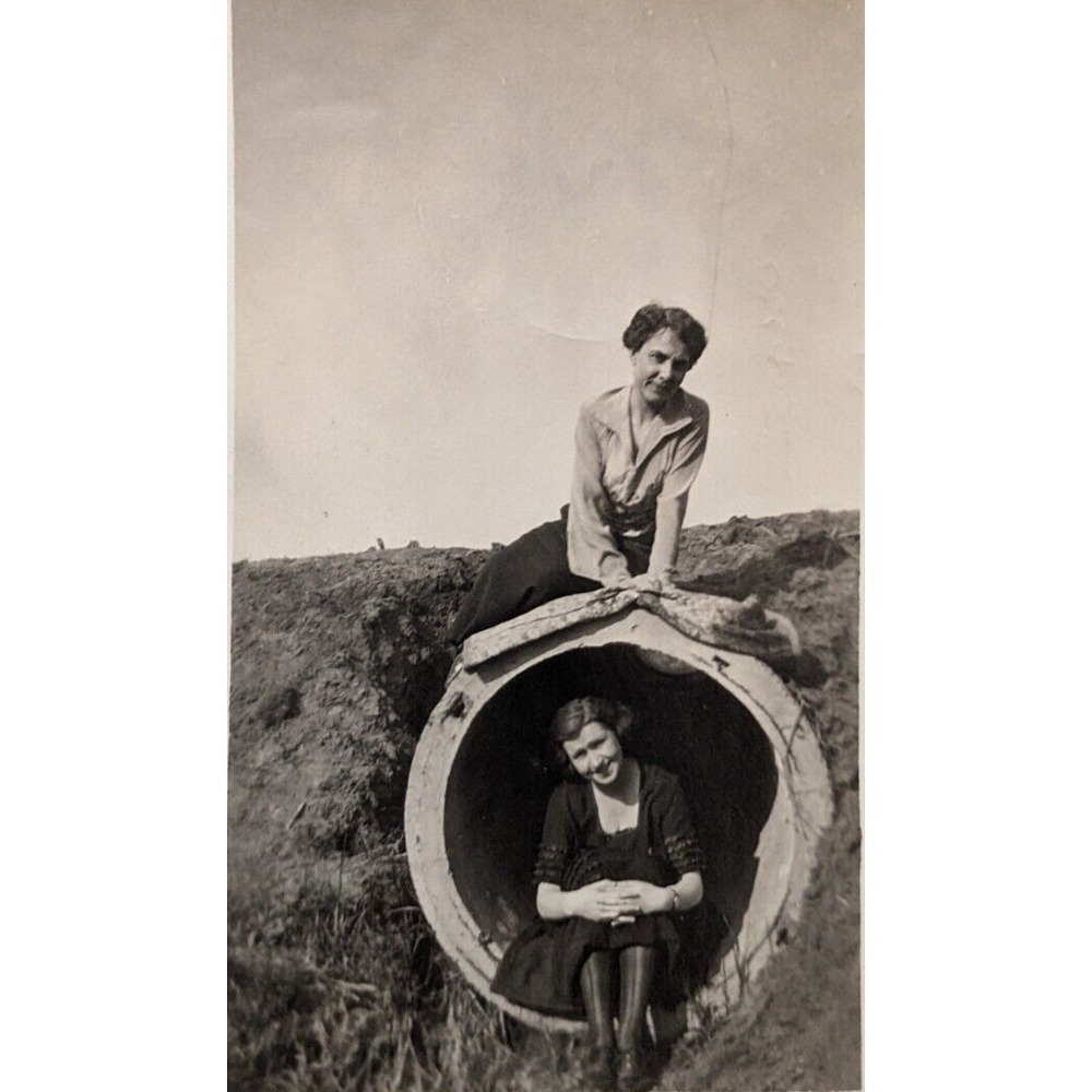 Two pretty young women posing in & on a large concrete pipe culvert VTG photo